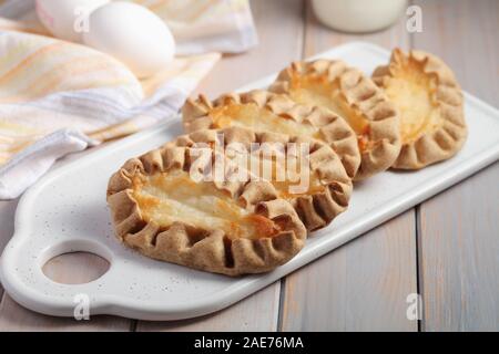 Karjalanpiirakat, Karelian pasties on a cutting board against eggs. Today it is a national dish in Finland Stock Photo