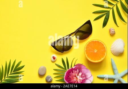 Summer Tropical Background. Palm Trees Branches, starfish and seashell on yellow background. Summer concept.Travel. Copy space. Stock Photo
