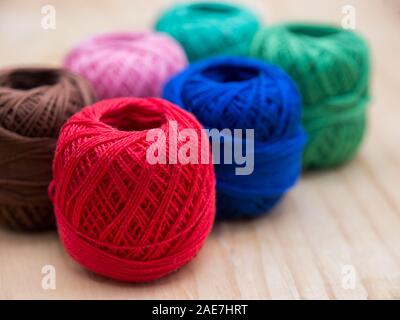 colored woolen thread and needles and meter close up on a wood background Stock Photo