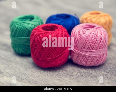 colored woolen thread and needles and meter close up on a wood background Stock Photo