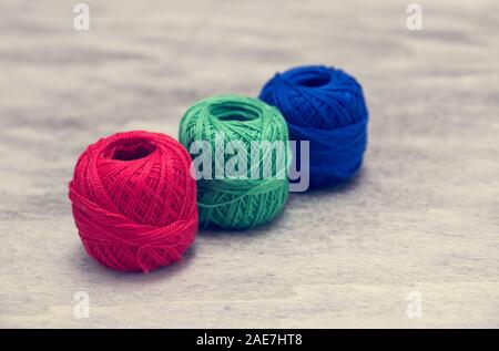 colored woolen thread and needles and meter close up on a wood background Stock Photo