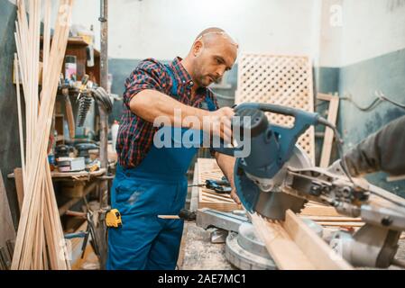 Carpenter works on circular saw, woodworking Stock Photo
