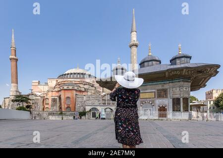 Beautiful girl in the white hat in front of Fountain of Ahmed III near Hagia Sophia at Istanbul Turkey. Stock Photo