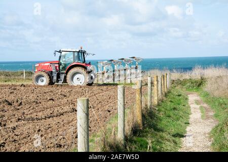 October 2019 - A farmer ploughs his field on a coastal farm in Trevose Head,Cornwall, UK Stock Photo
