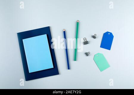 Blue and green notebooks with stationary objects on the grey background Stock Photo
