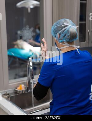 A veterinary surgeon goes through a thorough pre-surgery practice of scrubbing and then gowing up for surgery. Stock Photo