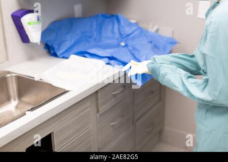 A veterinary surgeon goes through a thorough pre-surgery practice of scrubbing and then gowing up for surgery. Stock Photo