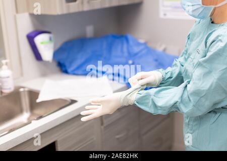 A veterinary surgeon goes through a thorough pre-surgery practice of scrubbing and then gowing up for surgery. Stock Photo