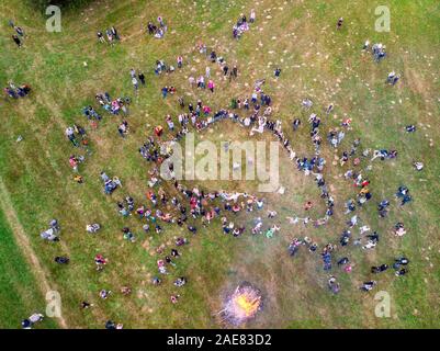 Round dance in Belarusian traditional clothes around bonfire, celebrating the pagan holiday of Kupalle, the midsummer festival marking the beginning o Stock Photo