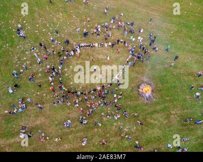 Round dance in Belarusian traditional clothes around bonfire, celebrating the pagan holiday of Kupalle, the midsummer festival marking the beginning o Stock Photo