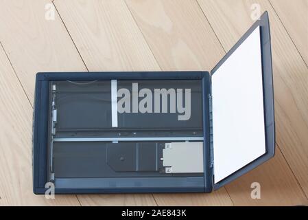 Open flatbed scanner on wooden table. Top view image. Stock Photo