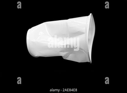 Crumpled plastic white Cup isolated on black Background Stock Photo