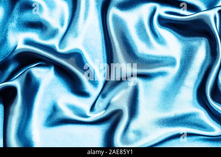 Silk cloth texture with waves toned in  trendy blue color. Classic blue color textile background Stock Photo