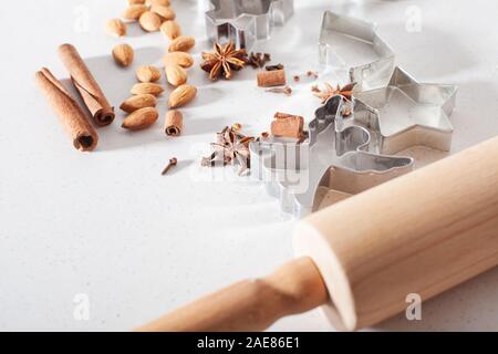 Cookie cuters Christmas gingerbread preparation. Baking Christmas gingerbread cookies in house kitchen on winter day. Stock Photo