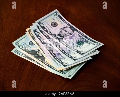 Pile of American (US) money with five, ten & twenty dollar bills featuring US president Abraham Lincoln Stock Photo