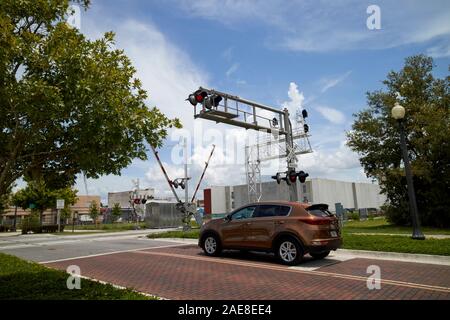 car waiting at barriers and red light at train railroad level crossing near lakefront park kissimmee florida usa Stock Photo