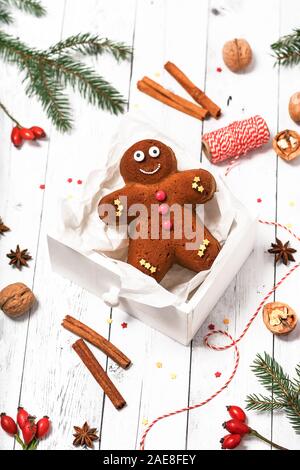 Homemade gingerbread man cake in a white wooden box as a small gift. Traditional Christmas food concept. Selective focus. Stock Photo