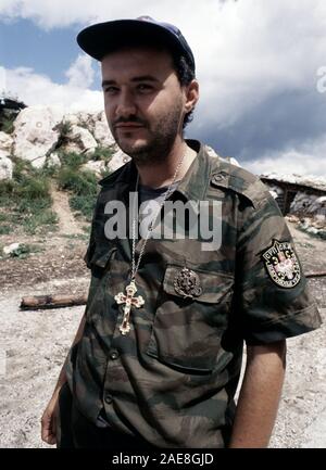 11th August 1993 During the Siege of Sarajevo: a Bosnian-Serb soldier outside his bunker on Mount Trebevic, above Sarajevo. He wears the shoulder patch of the Serb Volunteer Guard (Srpska dobrovoljačka garda or SDG), also known as Arkan’s Tigers, and the badge of the Serbian Army of Krajina. Stock Photo