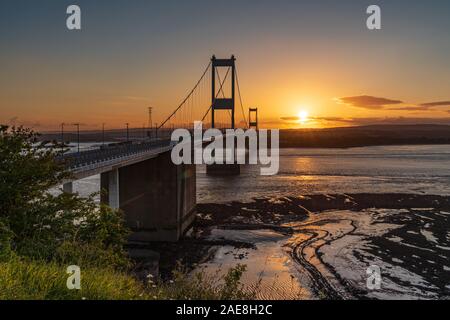 Aust, South Gloucestershire, England, UK - June 08, 2019: Sunset at the Severn Bridge, leading over the River Severn, seen from Aust Cliff