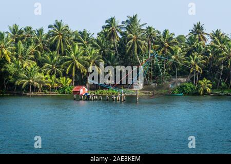 Chinese fisher net along the kollam kottapuram waterway along palm tree river shore Stock Photo