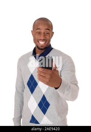 A young angry African American man standing in a sweater with phone in his hand smiling about the news, isolated for white background Stock Photo