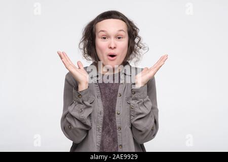 Intrigued excited young woman smiling from curiosity and interest listening carefully to interesting story. Studio shot Stock Photo