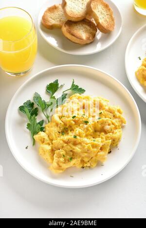 Scrambled eggs on plate over white stone background. Stock Photo