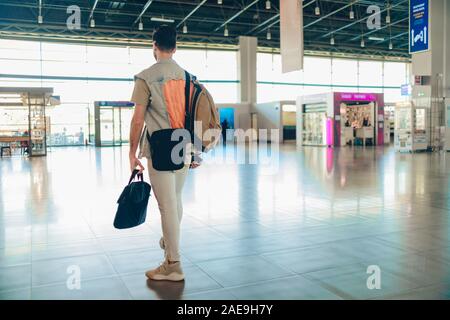 Man traveling by airplane. Young passenger waiting at the airport for a delayed flight Stock Photo