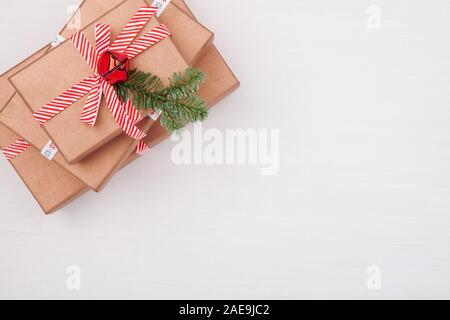Christmas gift boxes decorated fir tree branches and bells on white background Stock Photo