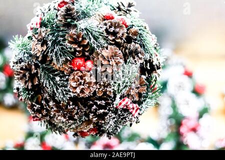 Christmas decorative softfocus background: artificial mistletoe ball of xmas tree branches and pinecones covered in snow Stock Photo