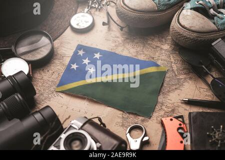 Solomon Islands Flag Between Traveler's Accessories on Old Vintage Map. Tourist Destination Concept. Stock Photo