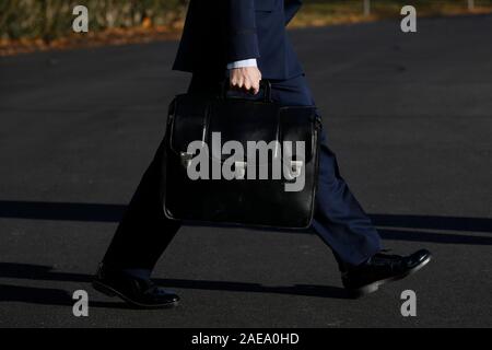 Washington DC, USA. 07th Dec, 2019. A military aide carries a briefcase containing codes for the nuclear arsenal following U.S. President Donald Trump on the South Lawn of the White House in Washington before his departure to Fort Lauderdale, Florida on December 7, 2019. Credit: MediaPunch Inc/Alamy Live News Stock Photo