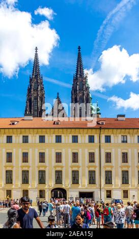 Tourists in the Second Courtyard of the Prague Castle Complex Administration Palace Building and steeples of St Vitus Cathedral Prague Czech Republic.