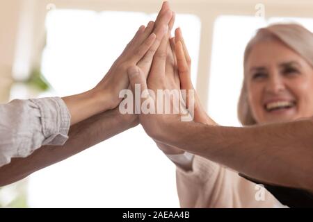 Close up employees giving high five after making business decision. Stock Photo