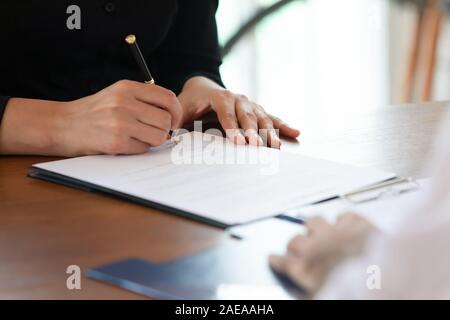 Close up cropped image young woman signing business agreement. Stock Photo