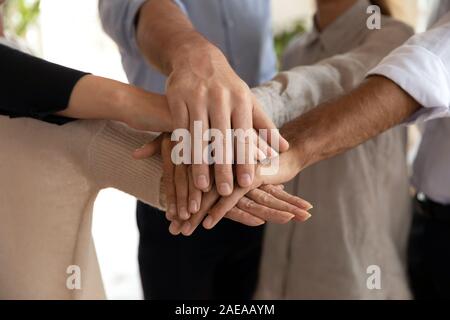 Close up international teammates joining hands together. Stock Photo