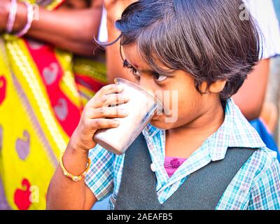 PUDUCHERRY, INDIA - DECEMBER Circa, 2018. Homeless and poor child drinking milk in the streets. Representing the situation of children in India, who d Stock Photo