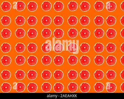 Seamless photo pattern of grapefruit slices on an orange background. Seamless pattern for your design. Stock Photo