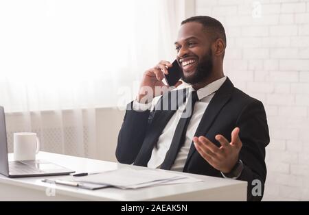 Excited businessman talking on mobile phone, making plans for weekend Stock Photo