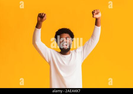 Black guy screaming Yes and raising clenched fists Stock Photo
