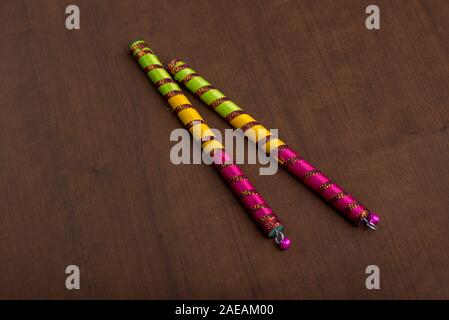 Dandiya sticks on a brown background. Raas Garba or Dandiya Raas is the traditional folk dance form the state of Gujarat & Rajasthan in India. Stock Photo