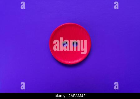 Big red button isolated on a purple background. Stock Photo