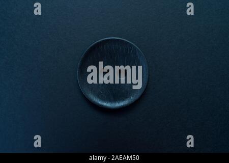Big black button isolated on a black background. Stock Photo
