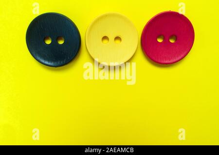 Three large multi-colored buttons on a yellow background. Copy space Stock Photo