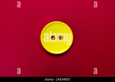 Big yellow button isolated on red background. Stock Photo