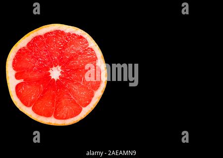 Grapefruit slice isolated on black background. Copy space. Stock Photo