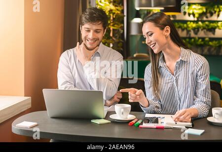 Millennial colleagues having business lunch at cafe Stock Photo