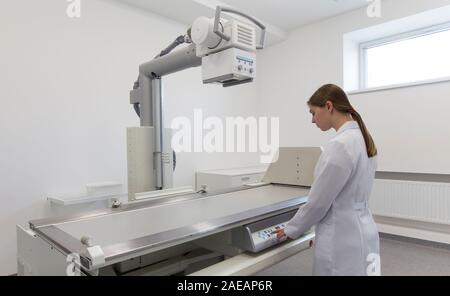 Female doctor in medical gown using X-ray machine Stock Photo