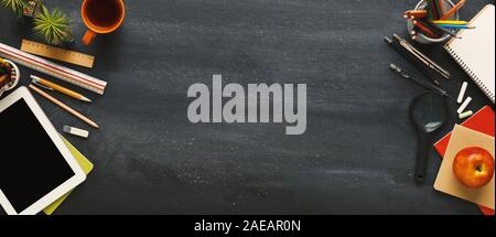 Supplies for school border on black chalkboard, panorama Stock Photo