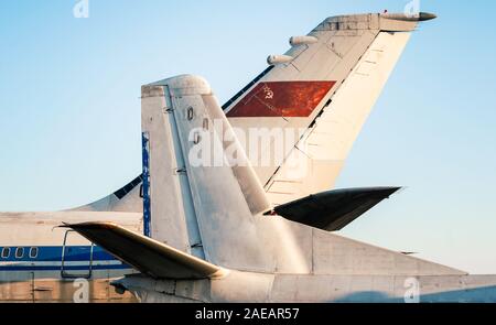 tail and wings of large old airliners with the symbol of the Soviet Union isolated on a blue sky background Stock Photo